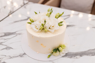 Obraz na płótnie Canvas Soft focused close up shot of beautiful white wedding or birthday cake with roses flowers on marble background. Festive event sweet bakery