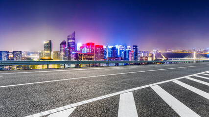 Fototapeta na wymiar Asphalt road and modern city skyline with buildings in Hangzhou at night.