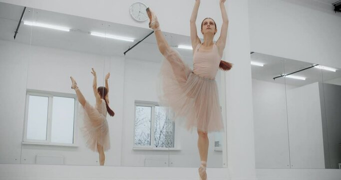 Ballerina dances on the ends of her pointe shoes near the mirror wall, woman dance on her toes, rehearsal at the ballet class, dancing practice, 4k DCI 60p Prores HQ