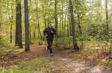 Sport Man runningon in forest. Healthy active man jogging