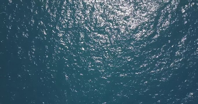 Top View Slow motion looping c ripples and wave, Refraction of sunlight top view texture sea side, Foaming and Splashing in the Ocean, Sunny Day, Slow Motion Video. Veiw from drone