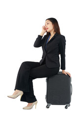 Isolated portrait of long hair beautiful businesswoman sitting on suitcase on white background.