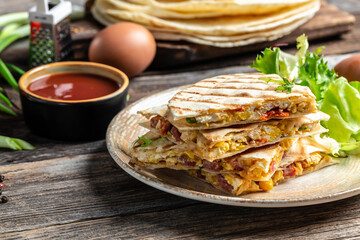 Quesadilla with scramble eggs, vegetables, ham and cheese. Mexican cuisine, Mexico and Latin America traditional restaurant menu dish