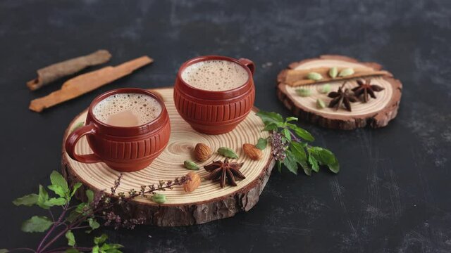 Indian Masala Chai traditional beverage tea with milk spices Kerala India Sri Lanka 4K slow motion video footage. Two cups organic tulsi tea ayurvedic herbal drink, good in winter immunity boosting.