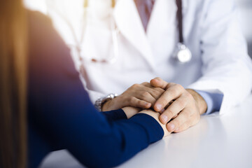 Unknown man-doctor reassuring his female patient, close-up. Perfect medical service, empathy in...