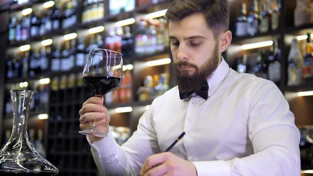 Young handsome man sommelier tasting red wine in cellar