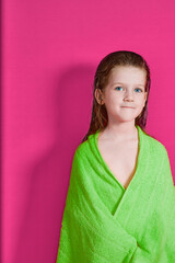 beautiful little girl, in a green robe on a pink background