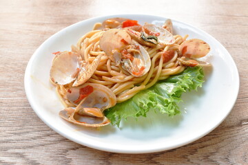 spicy stir fried spaghetti clams with pepper and basil leaf on plate