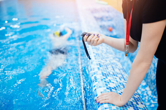 Swimming instructor coach people, woman hold in hand stopwatch during competitions in pool