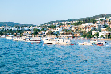 Obraz premium View of Bodrum Beach, Aegean sea, white houses, marina, sailing boats, yachts in Bodrum town Turkey.