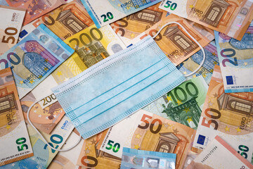Medical mask on top of a variety of european banknotes