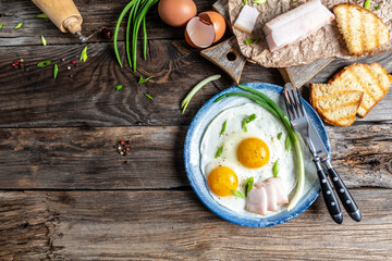 Traditional Ukrainian or belorussian food. Breakfast, lunch bacon, lard fried eggs and toast on old wooden table. banner, catering menu recipe place for text, top view