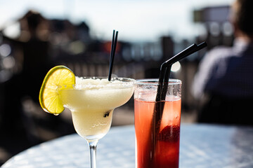 Enjoy cold summer cocktail alcohol drink, Margarita,with ice by the sea at the outdoor bar on a dock. 