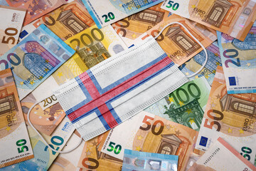 Obraz na płótnie Canvas Medical mask with the flag of Faroe Islands on a variety of european banknotes.(series)