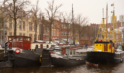 Fototapeta na wymiar Houseboats floating in the water of the Noorderhaven in the city center of Groningen in wintertime