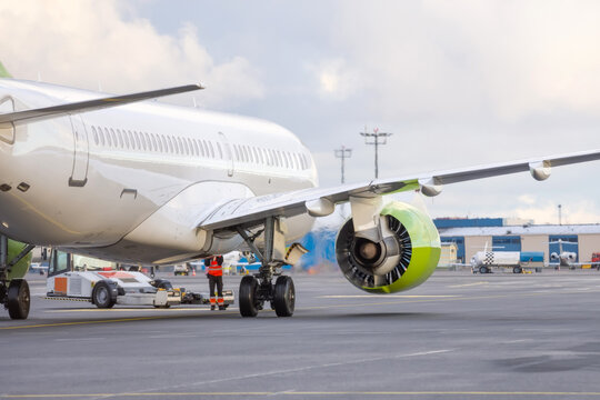 The plane pushes the tow tractor before starting the engines and taxiing, rear view.