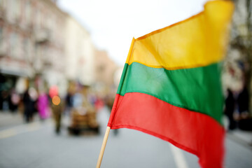 Lithuanian flag hold during celebration of Restoration of the State Day in Vilnius. - obrazy, fototapety, plakaty