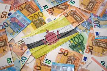 Obraz na płótnie Canvas Medical mask with the flag of Brunei on a variety of european banknotes.(series)