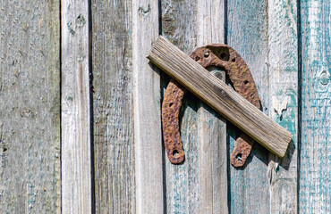 Old rusty horseshoe nailed to a wooden wall.