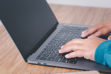 Female hand typing on computer keyboard of a laptop computer in office. Business and finance searching web, data analysis professional concept.