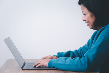 Naklejka premium Happy business woman using computer looking at screen working in internet sit at office desk, smiling female professional employee typing email on laptop at workplace business concept.