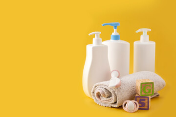 Baby hygiene and bath utensils on yellow background. Copy space