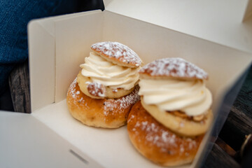 Traditional fastelavnsboller semla semlor swedish february dessert, traditional scandinavian sweet bread with almond cream paste and whipped cream. Cardamom bun and powdered sugar delicious treat