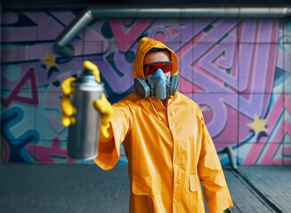 Graffiti artist pointing spray paint can to camera
