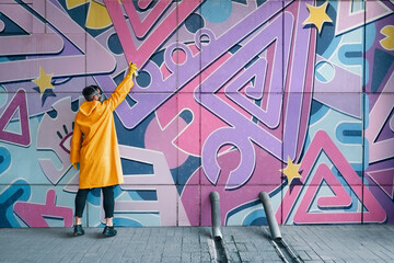 Street artist painting colorful graffiti on wall © GVS