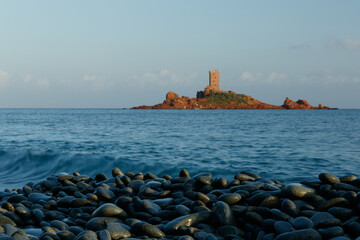 cobblestones on the beach and tower on rocky island