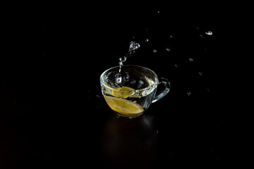 water splashes. freezing motion. frozen alcohol spray. a slice of lemon fell into a cup of water.