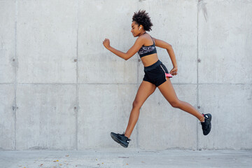 Fototapeta na wymiar Afro athletic woman running outdoors.