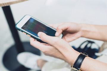 Two Businessman holding smartphone pointing and look directions change Average line Share price movement Stock trading in the up and down on display