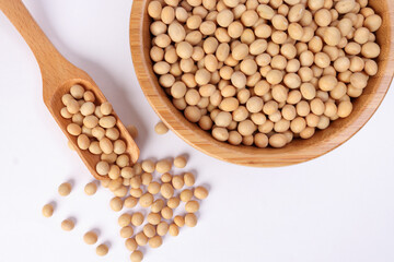 Soya bean in wooden bowl scoop spoon on white background