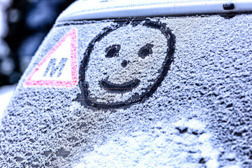 Frozen windshield in the snow with a heart