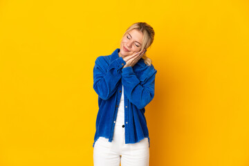 Young Russian woman isolated on yellow background making sleep gesture in dorable expression