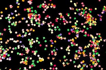 directly above view of colorful paper confetti isolated on black background