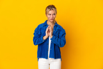 Young Russian woman isolated on yellow background scheming something