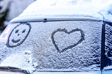 Frozen windshield in the snow with a heart