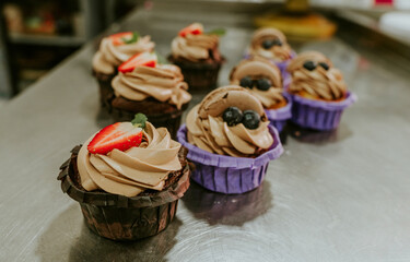 Cupcakes with cream and fresh berries on the table