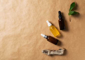 Serum bottles natural organic cosmetic with green leaf on brown