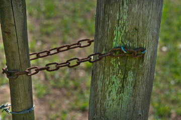 Wooden poles chained together for support on a farm to form the boundary.