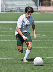Obraz premium Young Athletic boy kicking the ball during a soccer game