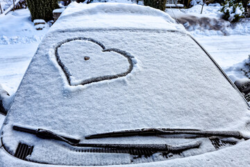 Frozen windshield in the snow with a heart