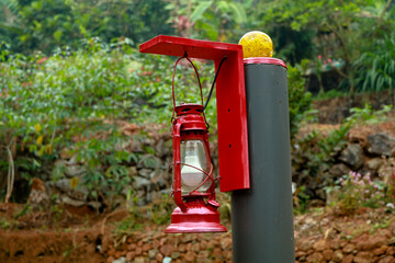 Fototapeta na wymiar Red color electric lamp hanging on a pillar