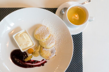 Cheesecakes with sour cream, currant jam, and lime tea