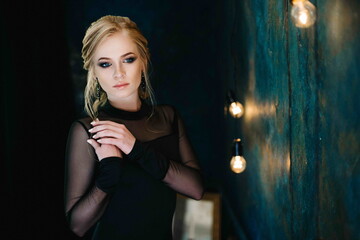 Blonde girl with blue eyes in a black dress © omelnickiy