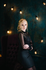 Blonde girl with blue eyes in a black dress © omelnickiy
