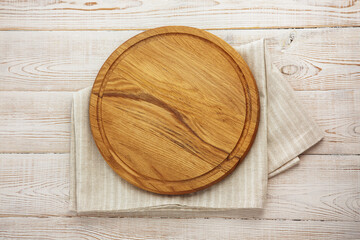 Fototapeta na wymiar Empty pizza board and napkin on white wooden top view.