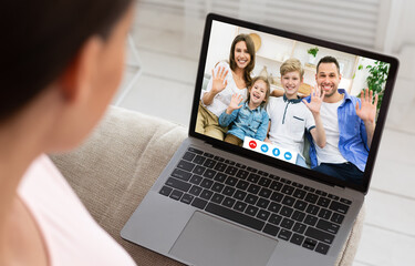 Millennial woman having online video conference with her relatives on laptop at home